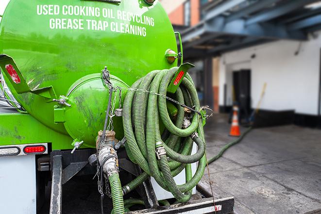 a technician pumping a grease trap in a commercial building in Rocklin, CA